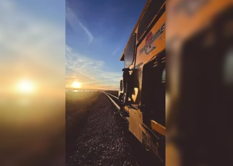 Sunset view from a train moving along the tracks.